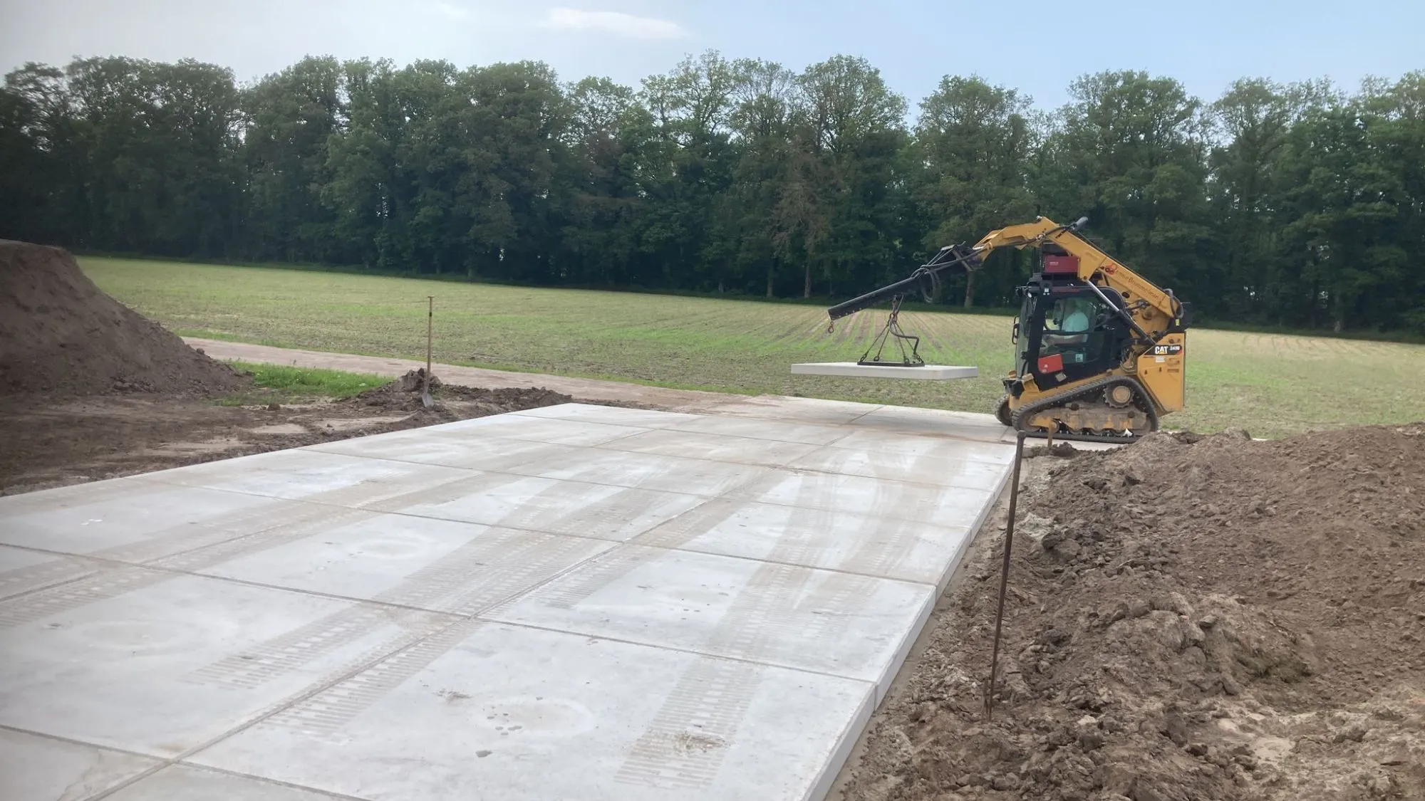 Zandbaan profileren en betonplaten leggen